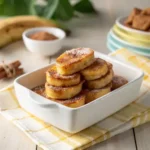 Stack of caramelized cinnamon banana slices in a ceramic dish, illuminated by soft morning light.
